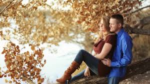 Couple sitting on a tree branch together