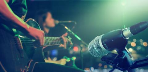 A guitarist in front of a microphone 