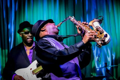 Musicians playing a guitar and saxophone