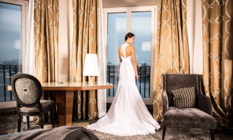 A bride in a wedding dress in front of a window