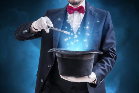 A magician holding a wand and a hat