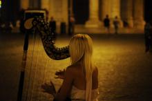 A harpist playing on the street at night 