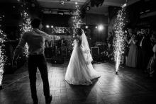 A bride and groom dancing surrounded by sparklers 